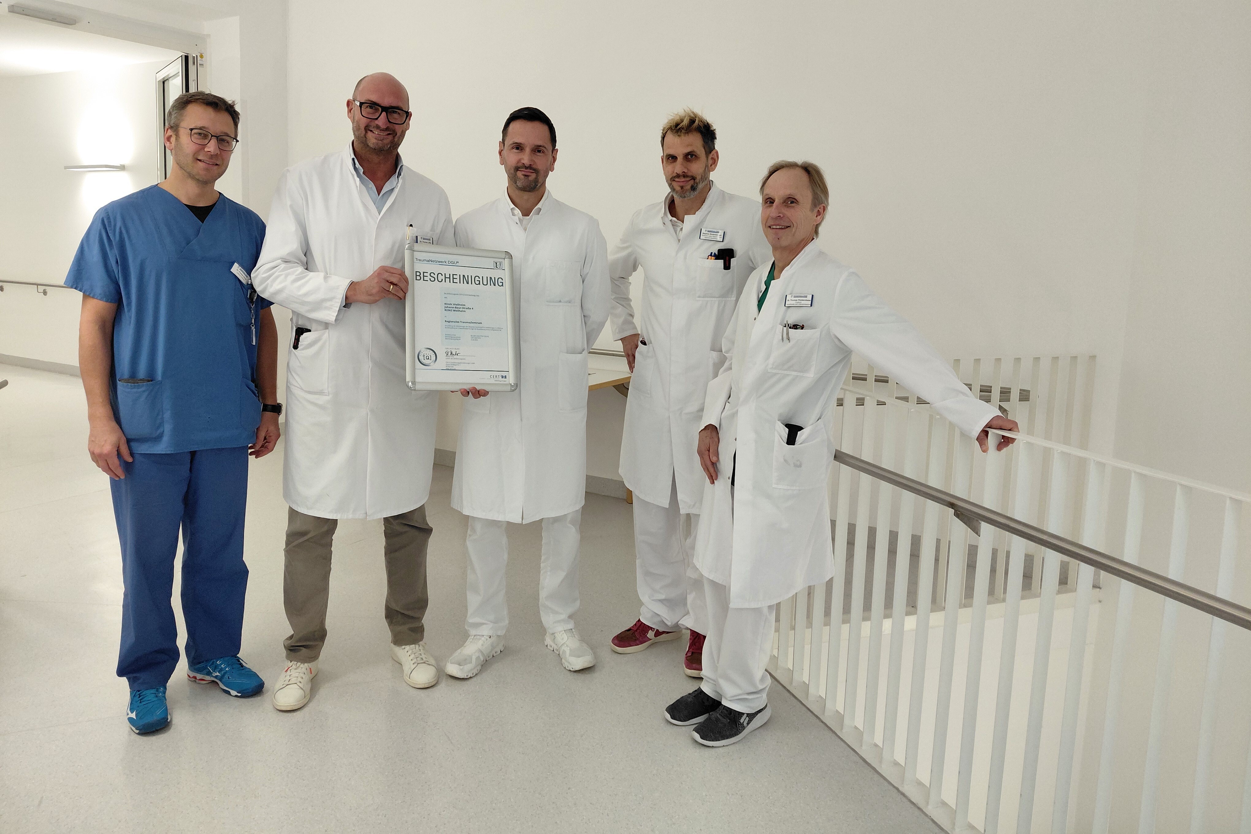 Chefärzte und Leitende Ärzte des Krankenhauses Weilheim zeigen das Zertifikat als Regionales Traumazentrum DGU: